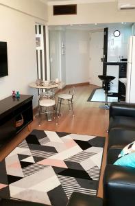 坎皮纳斯Flat Centro Campinas - L'Hirondelle 125的客厅配有沙发和桌椅