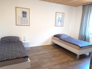 巴特施瓦尔陶Apartment in Bad Schwartau的一间卧室设有两张床,铺有木地板