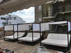 帕格拉Apartamentos Carabela II的一组坐在阳台上的白色椅子