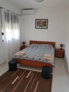 尤塔哈Villa Persik的一间卧室配有一张带两张矮凳和两张桌子的床。