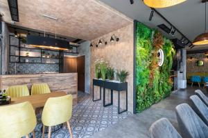 布尔加斯Хотел Камъните的餐厅内带桌椅的绿色墙壁