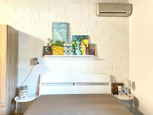 帕洛港Casa Alice a 100 mt dal mare, free wi-fi的卧室配有白色砖墙和床