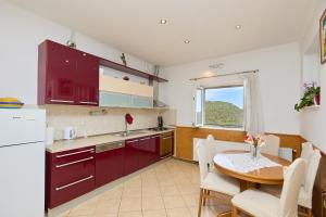 古维达里Agriculture & Holiday house Lasko的厨房配有红色橱柜、桌子和桌椅