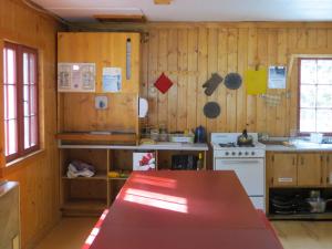 萨斯喀彻温河渡口HI Rampart Creek - Hostel的厨房设有木墙和桌子