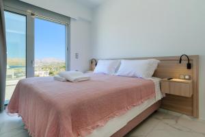 干尼亚Katakis LuxuryVillas的一间卧室设有一张大床和大窗户