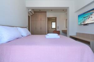 干尼亚Katakis LuxuryVillas的一间卧室配有一张带粉色毯子的大床