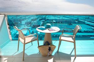 索托马里纳皮内塔酒店的阳台配有桌子和两把椅子,游泳池