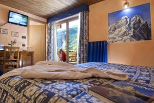 瓦托内切米拉蒙提旅馆的卧室配有一张挂有山壁画的床。