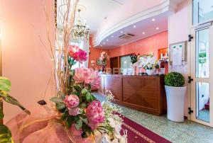 切塞纳蒂科Hotel Bisanzio的大堂设有粉红色的鲜花和现金登记册