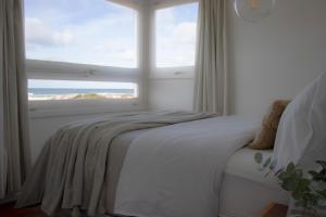 拉佩德雷拉ALMAR- Punta Rubia, La Pedrera的一间卧室设有一张床和一个大窗户