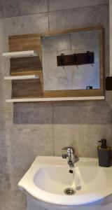 米科瓦伊基Domek pod lasem的浴室设有白色水槽和镜子