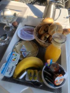 布鲁日布鲁日孔泰旅馆的包括香蕉和一篮面包的食品托盘