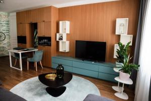 特伦钦ATRIO Apartments的客厅配有电视和蓝色橱柜。