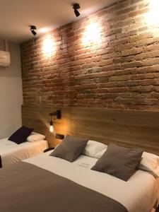 巴塞罗那坎东酒店的砖墙客房的两张床