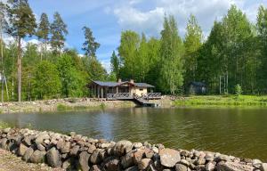 CesvaineDzirnavas Pirtsmāja的一座位于湖中,有桥的房子