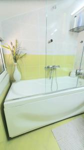 布德瓦Apartman Anja的浴室内设有带玻璃淋浴的白色浴缸
