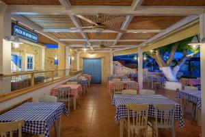 蒂加基Mythos Suites Hotel的一间设有蓝色和白色桌椅的餐厅