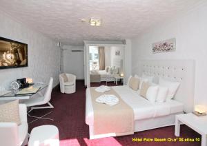 戛纳HOTEL PALM BEACH的卧室配有一张白色大床和一张书桌