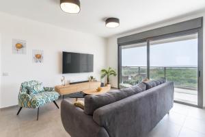 纳哈里亚Stunning 4-bedroom Apartment Next to Achziv Beach by Sea N' Rent的客厅设有大沙发和电视