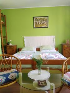 卡尼扎Hostel Bata的一间卧室配有一张床和一张带花瓶的桌子