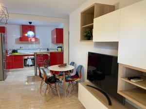 圣路易斯·德·萨比尼尔Apartamento Adimar的厨房配有红色橱柜和桌椅