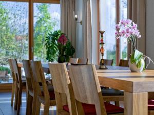 诺伊舍瑙Kraftquelle Waldhäuser的一间带桌椅和鲜花的用餐室