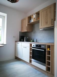策勒Ferienwohnung Danziger OG的厨房配有白色橱柜和黑烤箱。