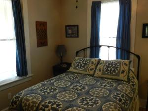 赫曼Helming Guest House的一间卧室配有带枕头的床和2个窗户。