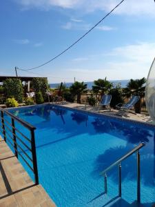 萨莫色雷斯Victory Apartments Hotel的一个带椅子的大型蓝色游泳池,并享有海景