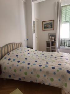 尼斯妮莎拉贝拉公寓的一间卧室配有一张带波卡圆床罩的床。