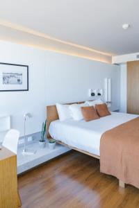 蒙得维的亚Opta Coliving Punta Carretas的卧室配有一张白色大床和一张书桌