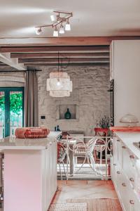 巴代尔纳La Vita Bella Villa的厨房配有白色橱柜和石墙