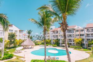 蓬塔卡纳Playa Turquesa Ocean Club的享有棕榈树度假村的游泳池景致