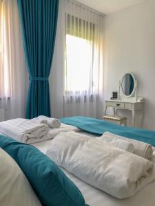 锡比乌Gizell Apartment 1的一间卧室配有两张带蓝色窗帘的床和窗户。