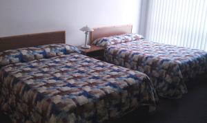 Cabano皇家汽车旅馆的一间卧室配有两张床和一张带台灯的桌子