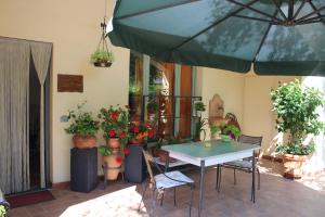 蒙泰斯佩尔托利Casa le Betulle的一个带桌子和一些盆栽植物的庭院