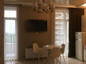 敖德萨Сдам квартиру у моря Элегия парк Аркадия的厨房配有桌椅,墙上配有电视。