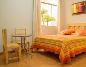 塔克纳Takora Inn的一间卧室配有一张床、一张桌子和一个窗户。