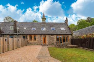 亚历山德里亚Fantastic Cottage in Loch Lomond National Park的一座带木栅栏的古老石头房子