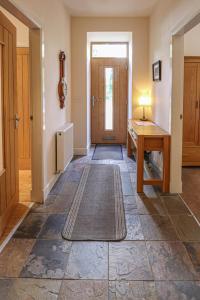 亚历山德里亚Fantastic Cottage in Loch Lomond National Park的走廊上设有门、桌子和地毯