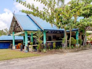 帕朗卡拉亚Capital O 90417 Hotel Batu Suli Internasional的蓝色屋顶和一些树木的房子