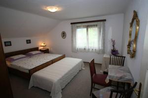 克拉根福Villa Lindwurm的一间卧室设有两张床、一张桌子和一个窗口