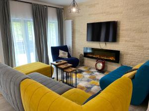 布什泰尼Casa Skadi, Zamora,Busteni的客厅设有黄色沙发和壁炉