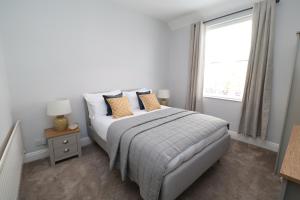 蒂斯河畔斯托克顿The Hideaway - IH113AHIG的白色卧室配有带枕头的床和窗户