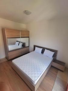 巴尔New Luxury Apartments BaR的一间卧室配有一张大床和木制床头板