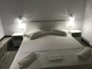 南埃福列CasaRiana 4的一张带枕头的白色床和两盏灯