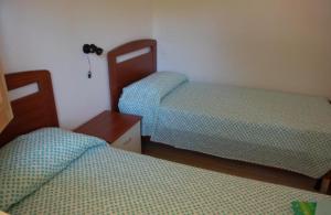 Isca sullo IonioMIMOSA CAMPING的一间卧室配有两张床、床头柜和两张床。