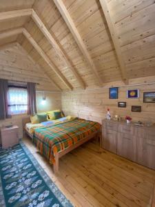 莫伊科瓦茨Tara Riverside的木制客房内的一间卧室,配有一张床