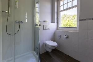 阿伦斯霍普Strandläufer 04的一间带卫生间和淋浴的浴室以及窗户。