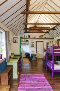 怀特帕里施Bramble Cottage的客厅配有紫色家具和木制天花板